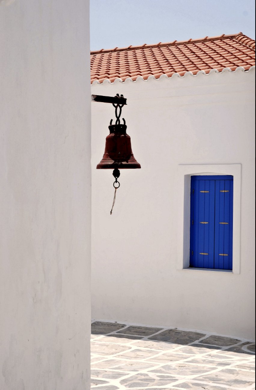 A whitewashed Cycladic chapel belfry against a blue sky on Kythnos
