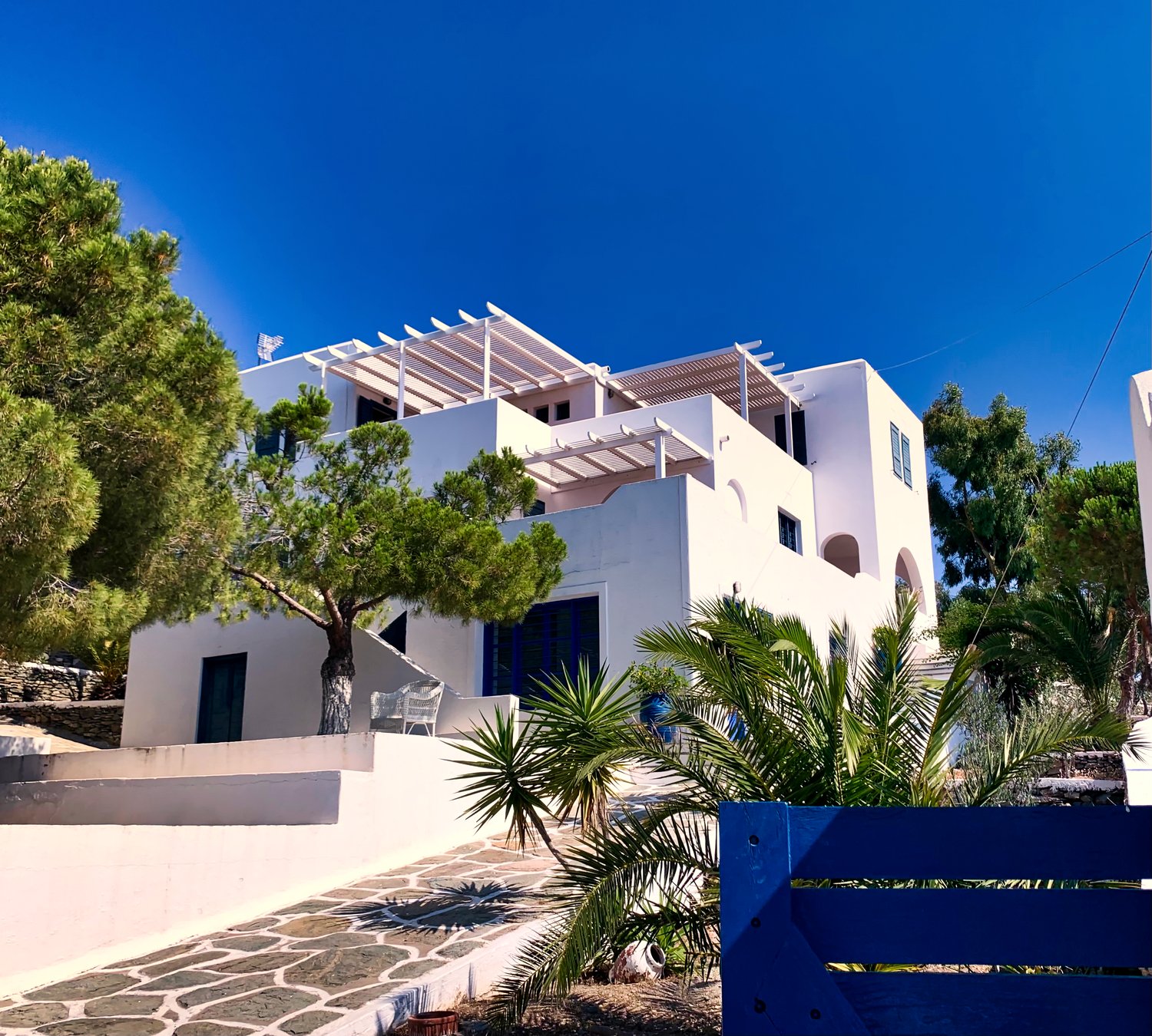 The whitewashed villa exterior of Verros Suite among the pines